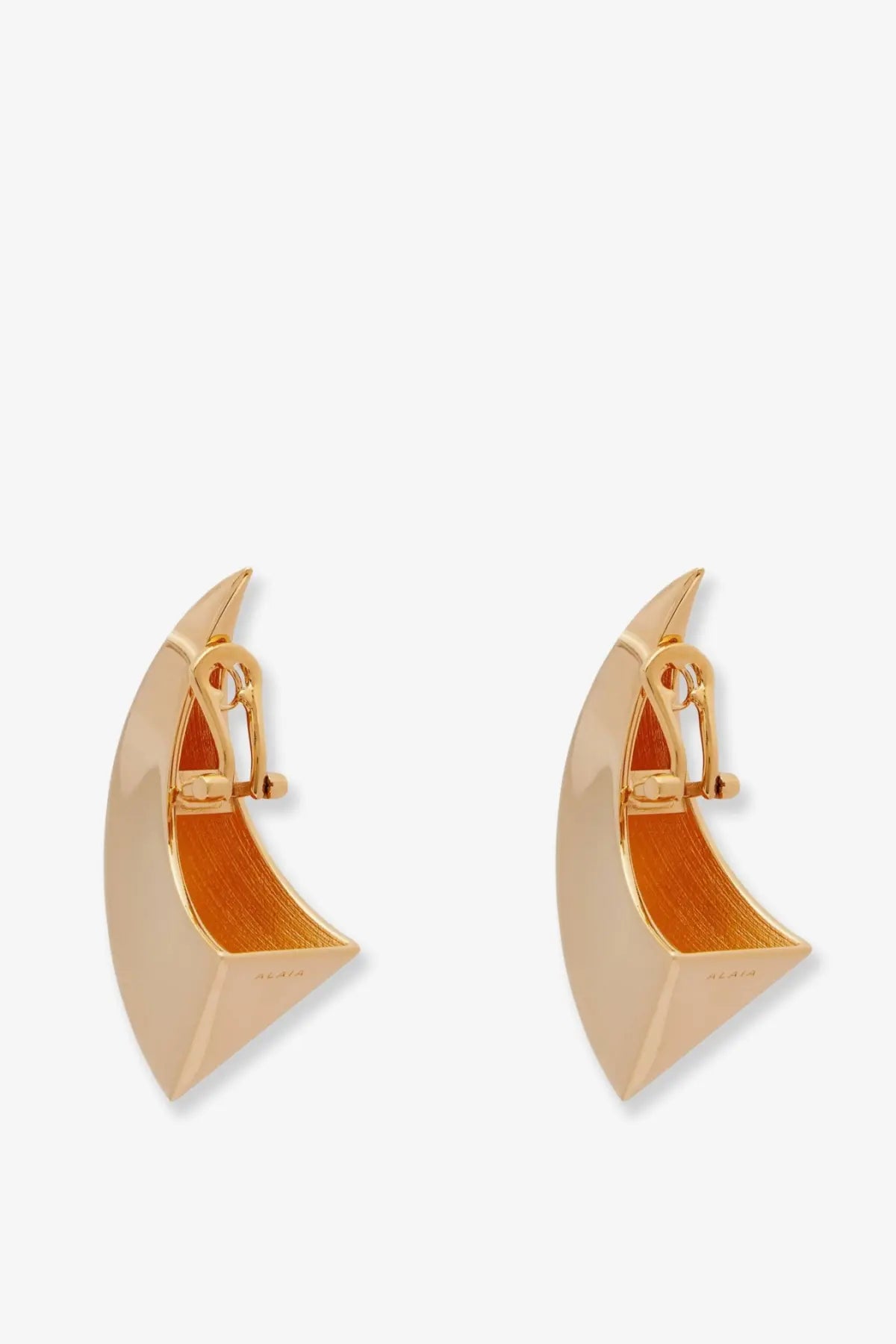 Alaïa women’s gold brass crescent clip earrings with polished exterior and orange textured interior