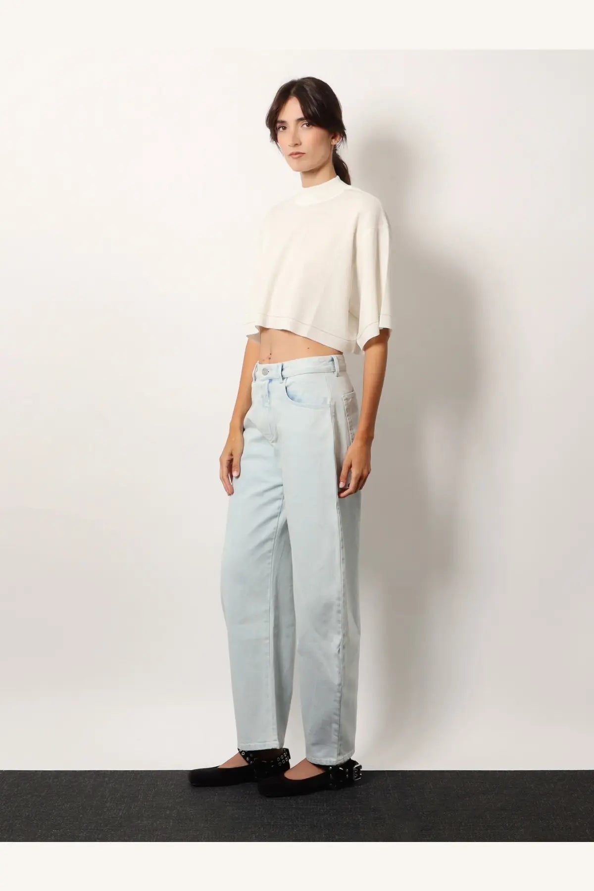 Light blue wide-leg denim jeans with high waist and classic five-pocket design paired with Alaïa white cropped cotton blend top