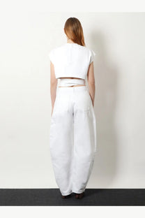 Alaïa women’s curved white denim trousers paired with a white cropped top in a stylish wide-leg ensemble