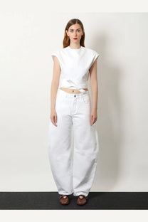 White sleeveless cropped top with front tie detail paired with ALAÏA women’s curved white denim trousers