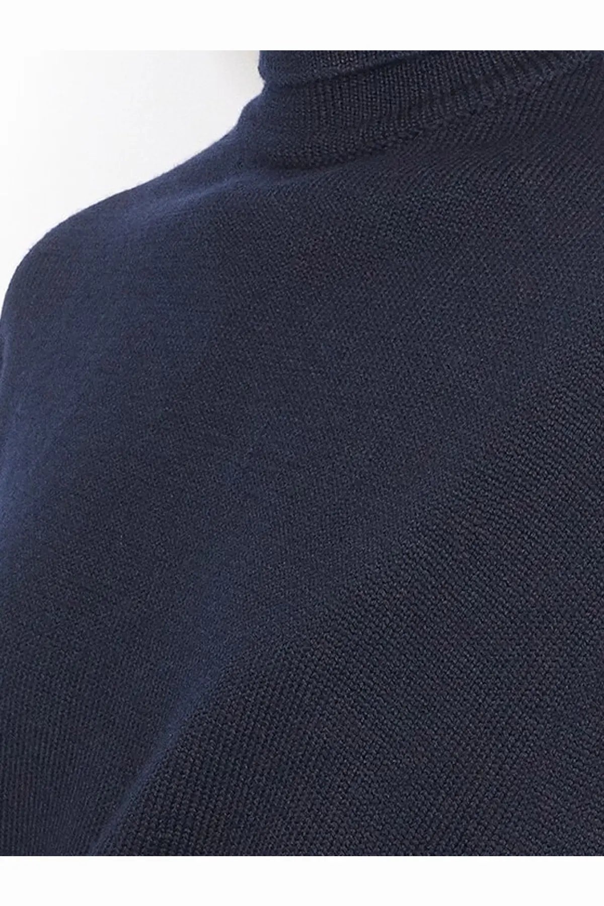 Alaïa women’s cut out virgin wool dress in black shown with a navy blue fine knit turtleneck sweater
