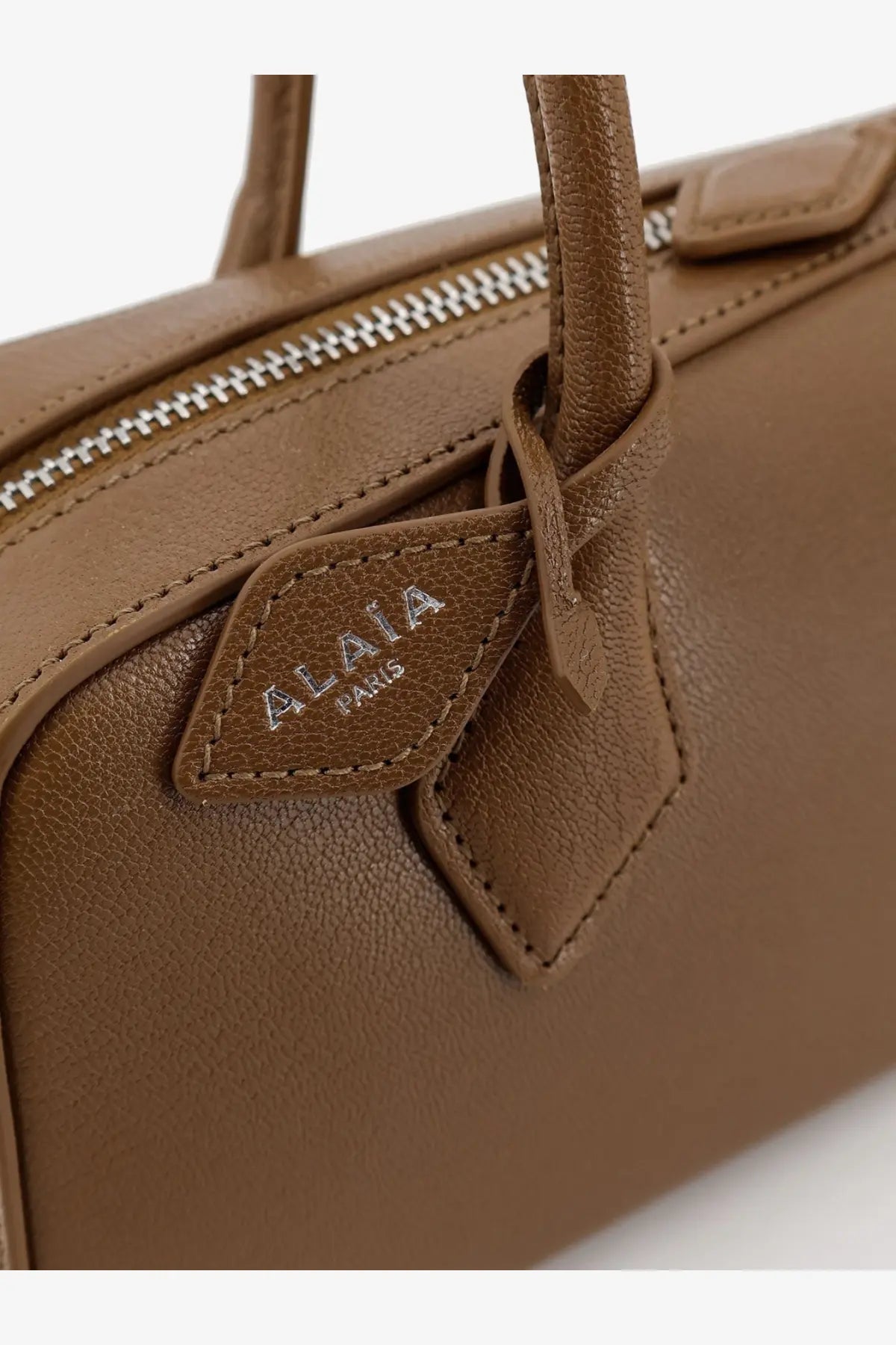 Alaïa women’s le teckel tan leather shoulder bag with silver zipper and diamond shaped alaïa paris brand tag