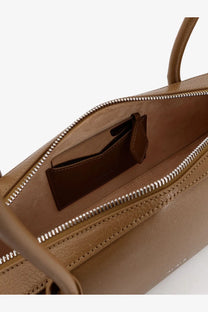 Alaïa women’s green leather shoulder bag with tan leather tote, silver zipper, and stitched handles