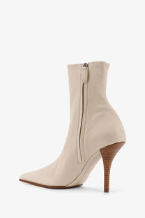 Alaïa women’s beige leather ankle boot with a slender textured wooden heel and pointed toe