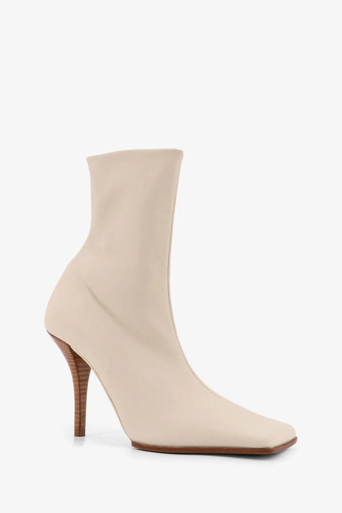 Alaïa women’s leather ankle boot in beige with a cream-colored sleek design square toe and slender wooden heel