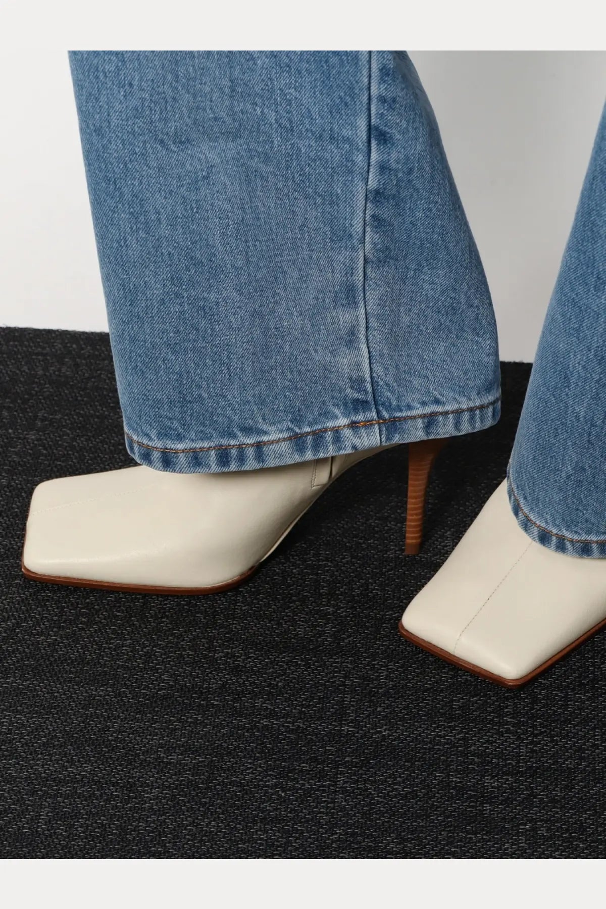 Alaïa women’s cream-colored square-toe ankle boots with slender wooden heel and smooth leather upper in beige