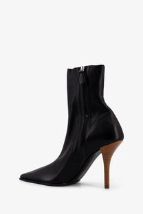 Alaïa women’s black leather ankle boot with pointed toe and wooden textured high heel front view