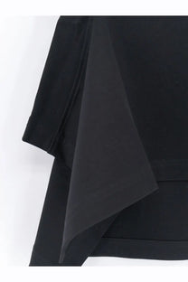 Alaïa women’s paneled cotton shirt in black showing smooth matte fabric with clean stitching along the edge
