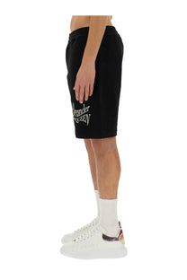 Alexander McQueen men’s black cotton Bermuda sweat shorts with white embroidered branding on the left leg