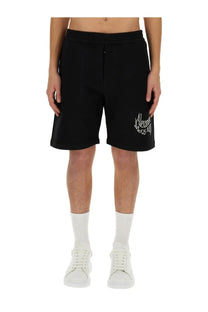 Alexander McQueen men’s Bermuda black sweat shorts with white embroidered logo on left thigh