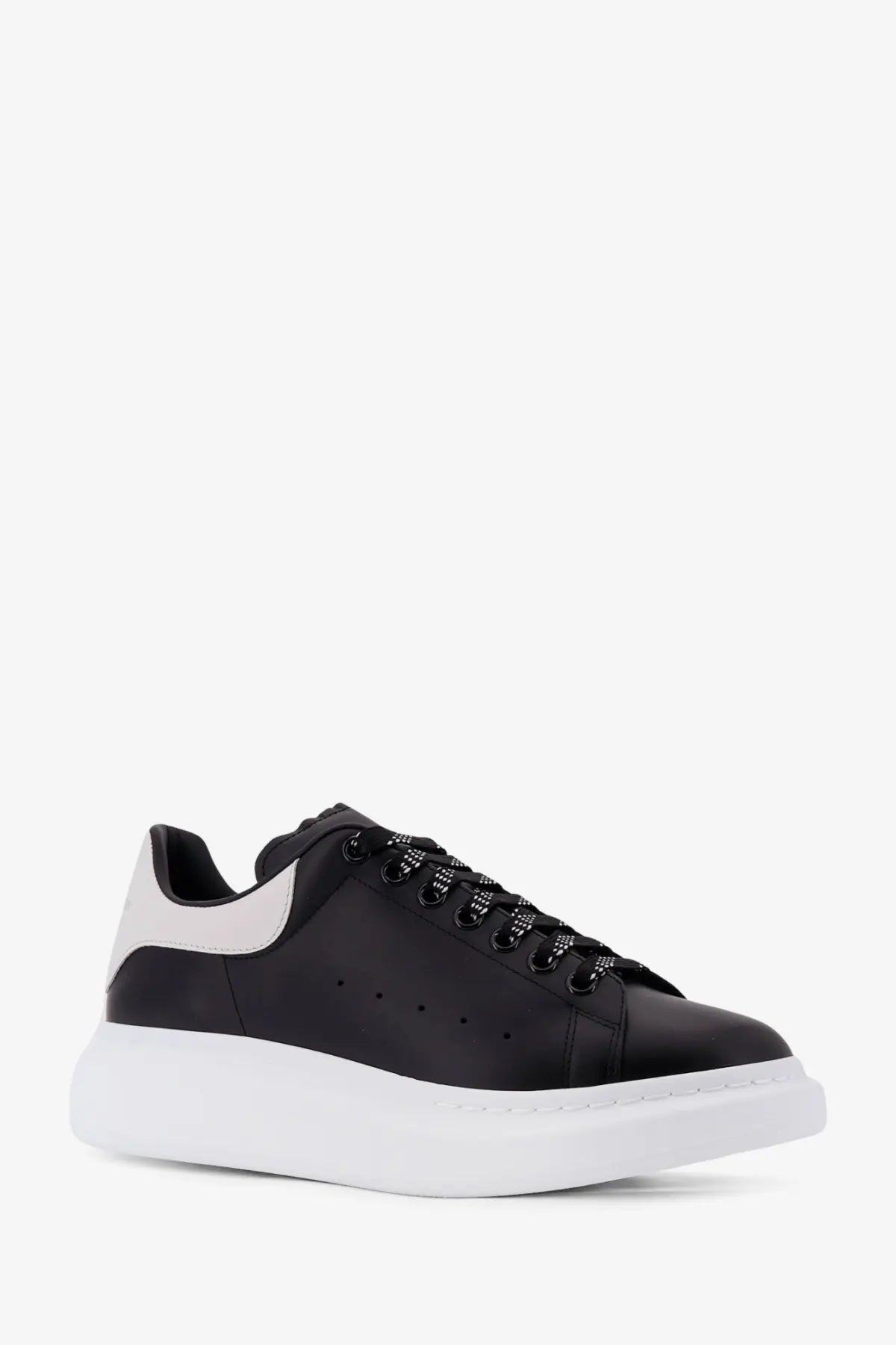 Alexander McQueen men’s low top black leather sneakers with white rubber sole and contrasting white heel tab back view