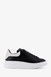 Alexander McQueen men’s low top leather sneakers in black and white with a chunky sole front view
