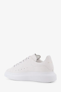 White leather alexander mcqueen men’s low top sneaker with chunky sole and subtle branding on the heel back view