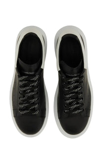 Alexander McQueen men’s oversized sneaker in black leather with white rubber soles and perforated detailing