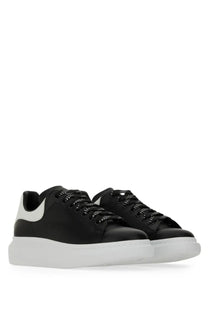 Alexander McQueen men’s oversized sneaker black leather with white rubber soles and studded black laces shown from back