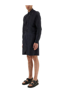 Black long-sleeved tailored shirt dress with pleated front panels paired with alexander mcqueen men’s denim blue shorts