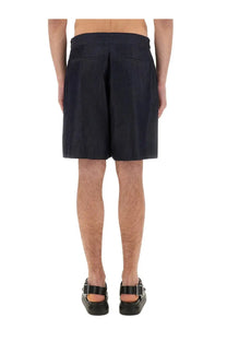 Alexander McQueen men’s short in denim blue featuring dark navy pleated shorts with tailored waistband and structured design