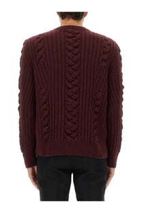 Alexander mcqueen men’s wool sweater red shown from the back with intricate burgundy cable-knit braided patterns on sleeves and back
