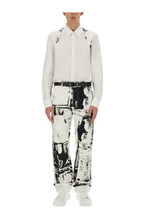 Alexander McQueen men’s white workwear jeans with black graffiti-like abstract distressed pattern