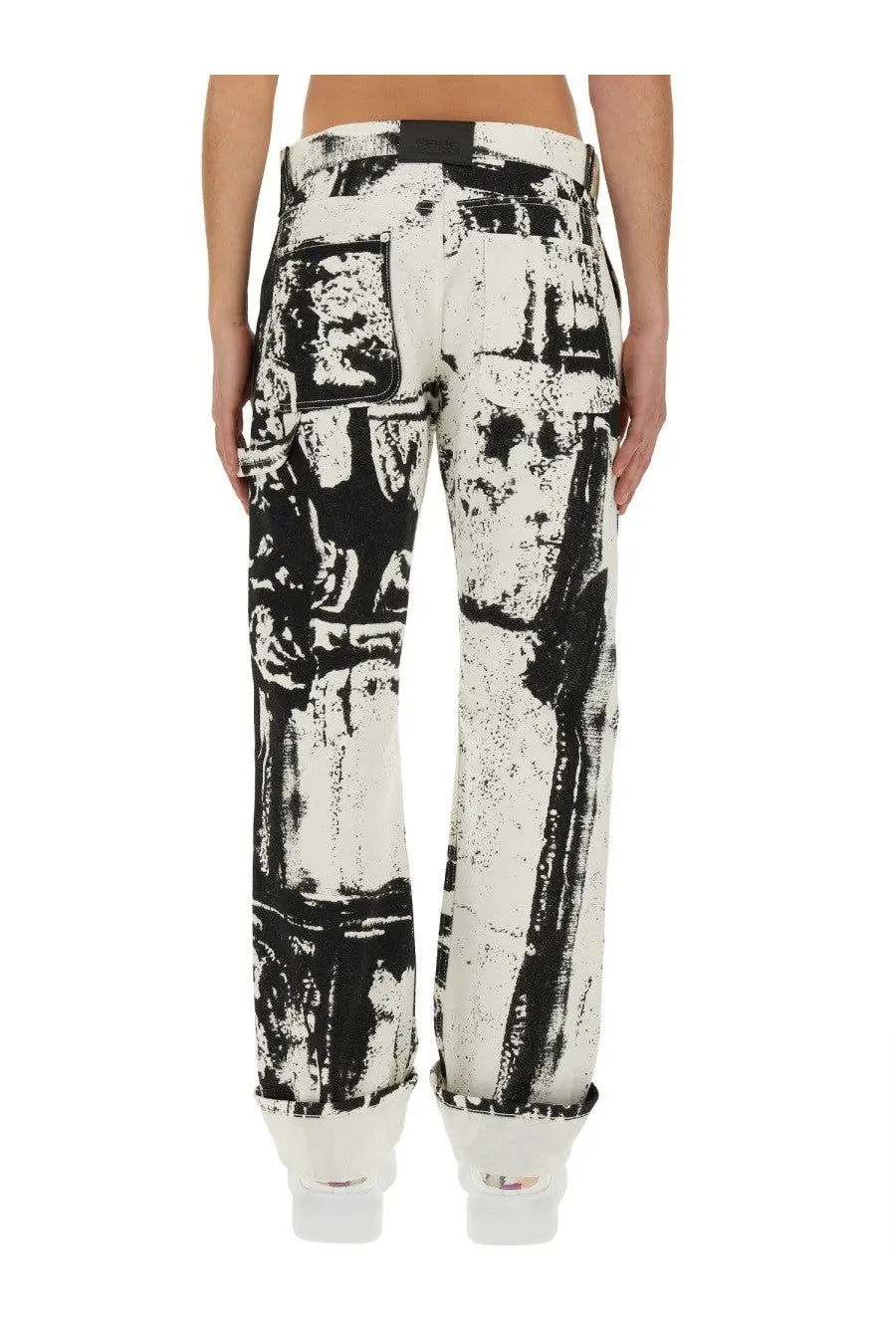 Alexander McQueen men’s white denim workwear jeans with bold black distressed stencil graphic print