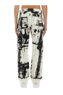 Alexander McQueen men’s white denim workwear jeans with bold black distressed stencil graphic print