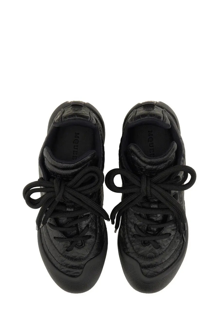 Black quilted leather alexander mcqueen women’s flexion sneaker with glossy finish and laces tied in bows