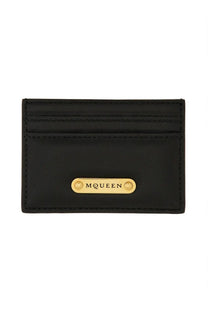 Alexander McQueen women’s black leather card holder with gold tone McQueen plaque front view