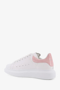 White alexander mcqueen women’s oversize leather sneaker with pink croc embossed heel tab and thick white sole back view