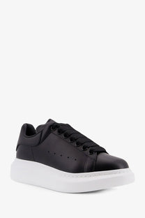Black leather alexander mcqueen women’s oversized sneaker with thick white rubber sole and black laces
