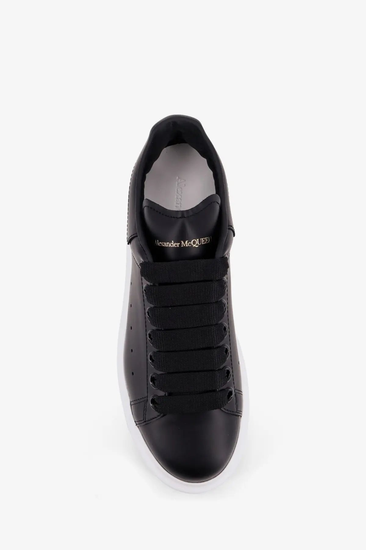 Alexander McQueen women’s oversized black leather sneaker with sleek minimalist design and contrasting white sole