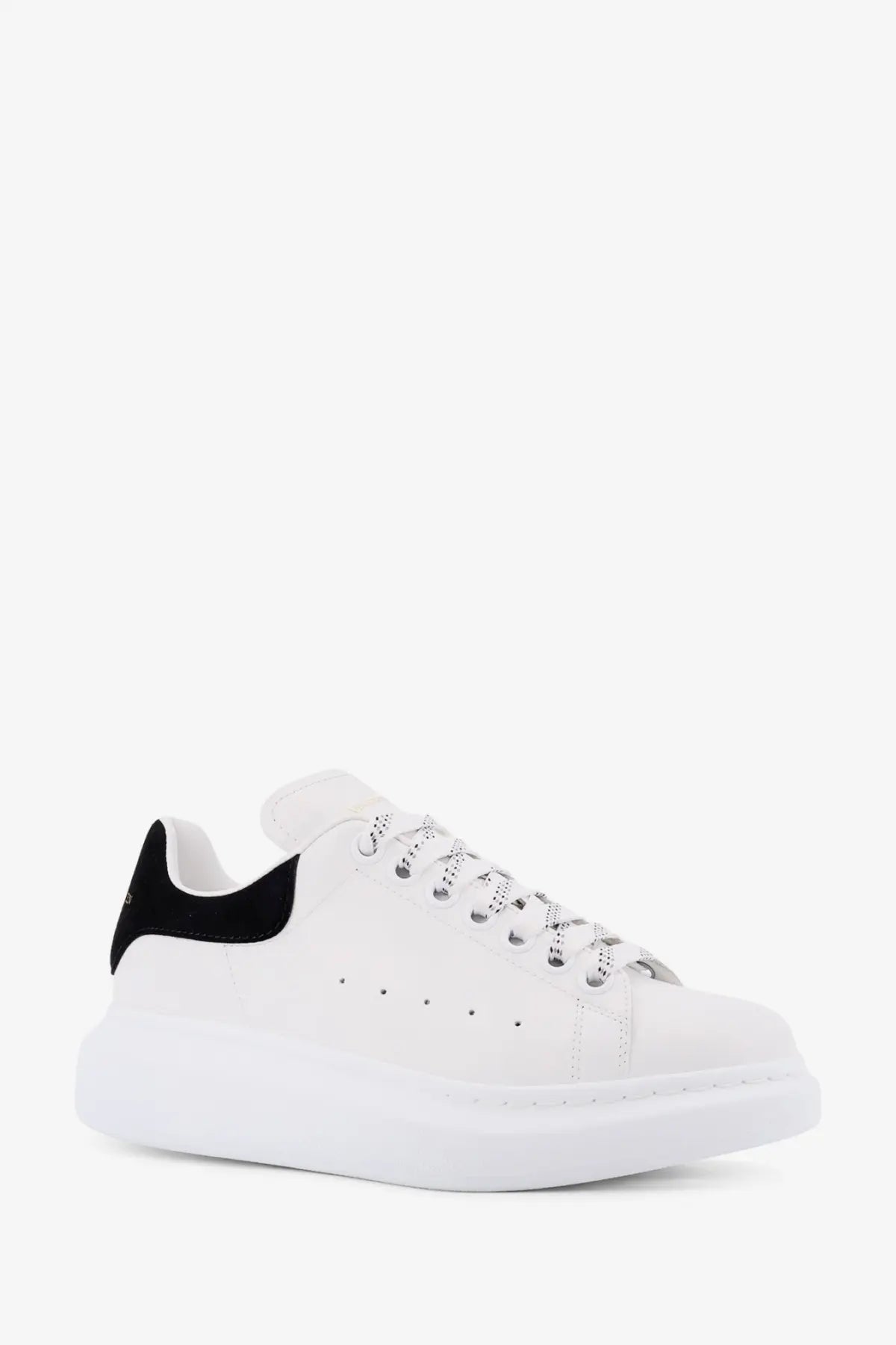 White Alexander McQueen women’s oversized leather sneaker with black heel tab and silver toned laces shown from back