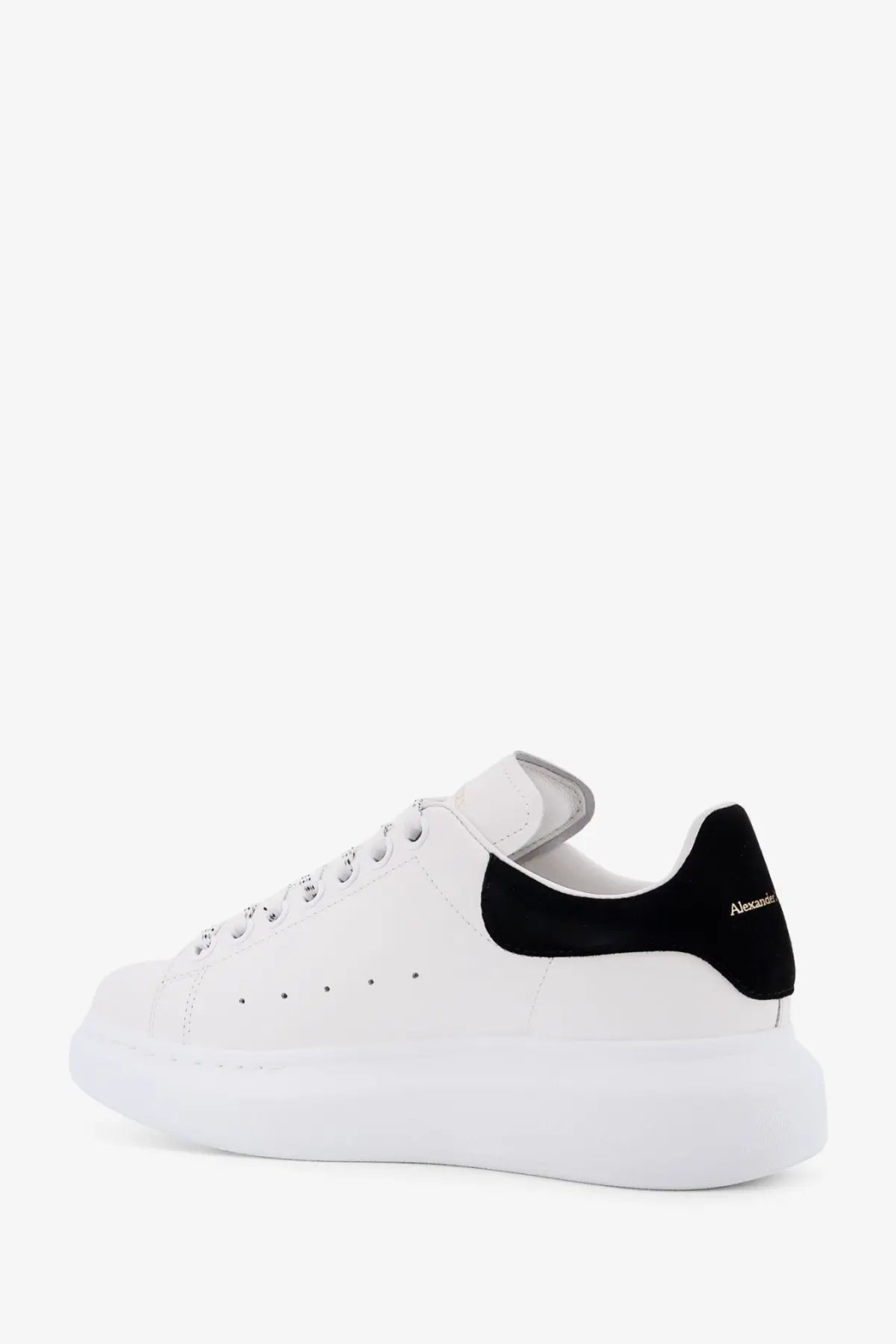 White leather Alexander McQueen women’s oversized sneaker with black suede heel tab and matching laces side view