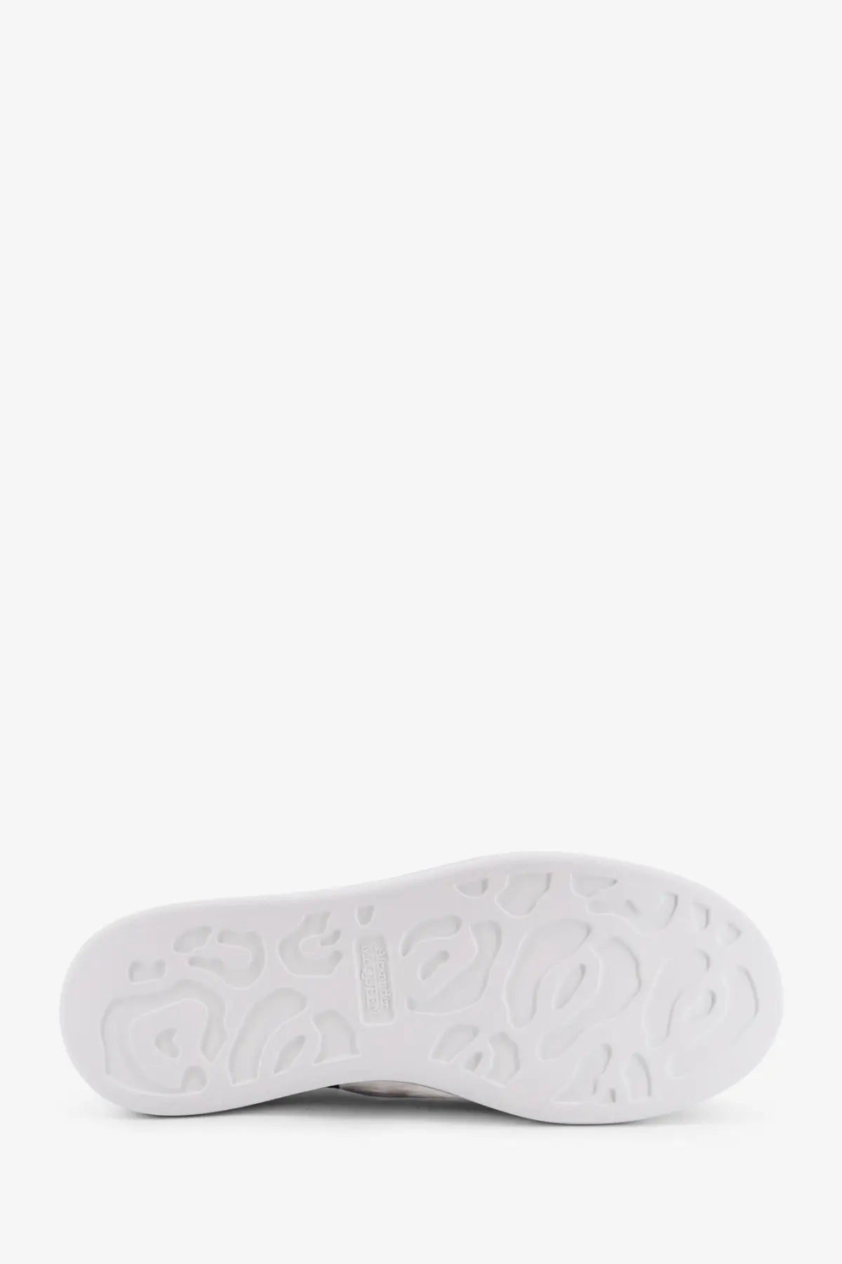 White rubber sole with embossed leopard print pattern on alexander mcqueen women’s oversized black leather sneakers