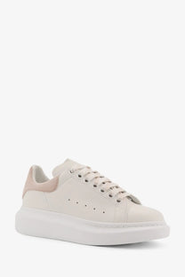 Alexander McQueen women’s oversized cream leather sneaker with thick white sole and pink heel tab accents back view