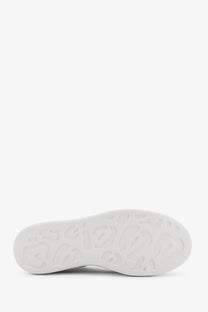 Close-up of white rubber sole with embossed alexander mcqueen logo on women’s oversized leather sneakers