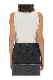 Alexander mcqueen women’s ribbed tank top in white paired with a dark gray denim skirt for casual wear