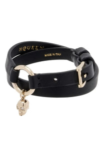 Alexander McQueen women’s black leather wrap bracelet with gold-tone skull charm and buckle featuring mcqueen branding
