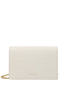 Cream-colored crocodile-embossed leather Alexander McQueen women’s small skull bag with gold chain strap and logo embossed