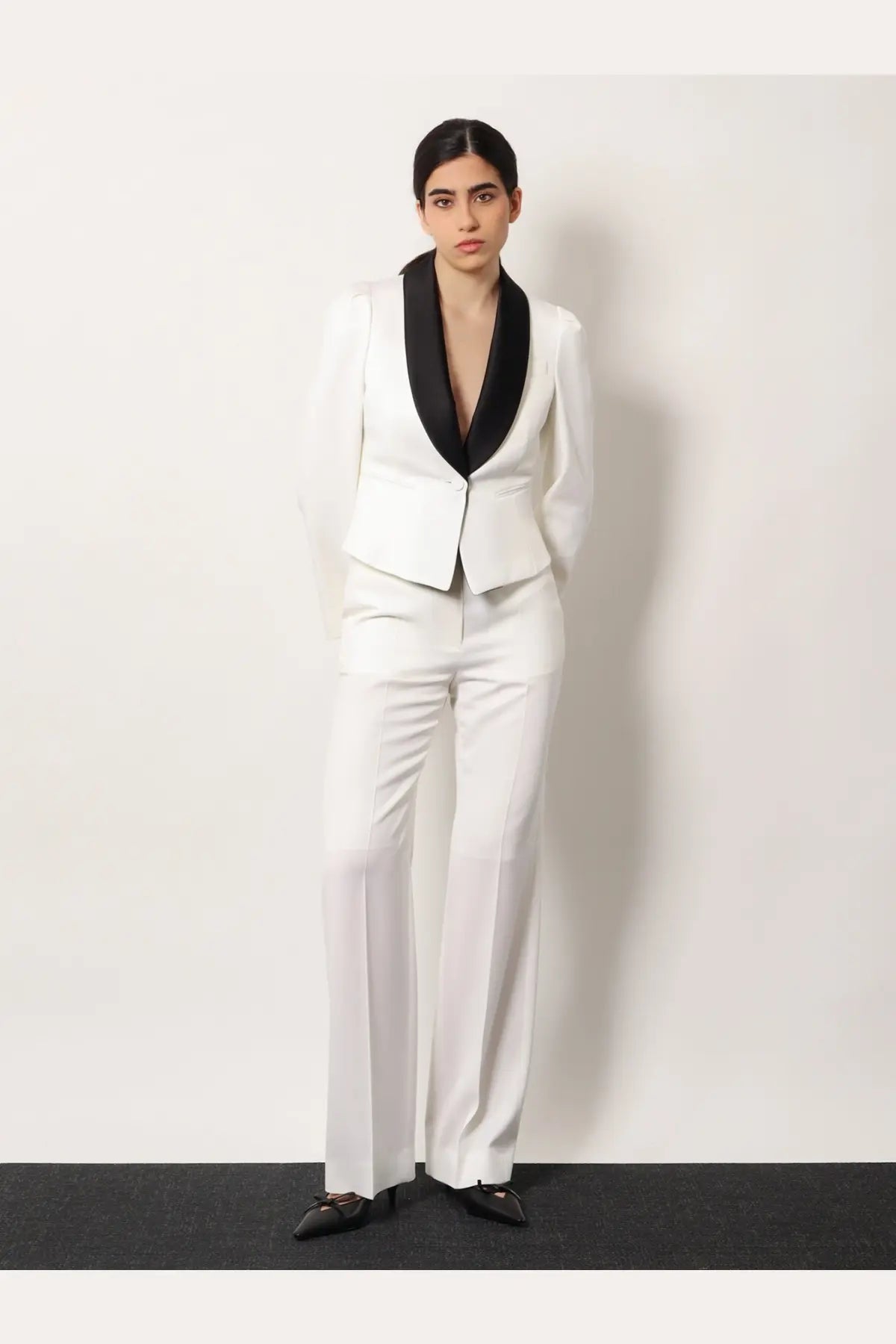 White tailored suit jacket with black satin lapels paired with Alexander McQueen women’s wool trousers white