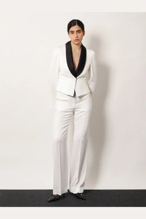 White tailored suit jacket with black satin lapels paired with Alexander McQueen women’s wool trousers white