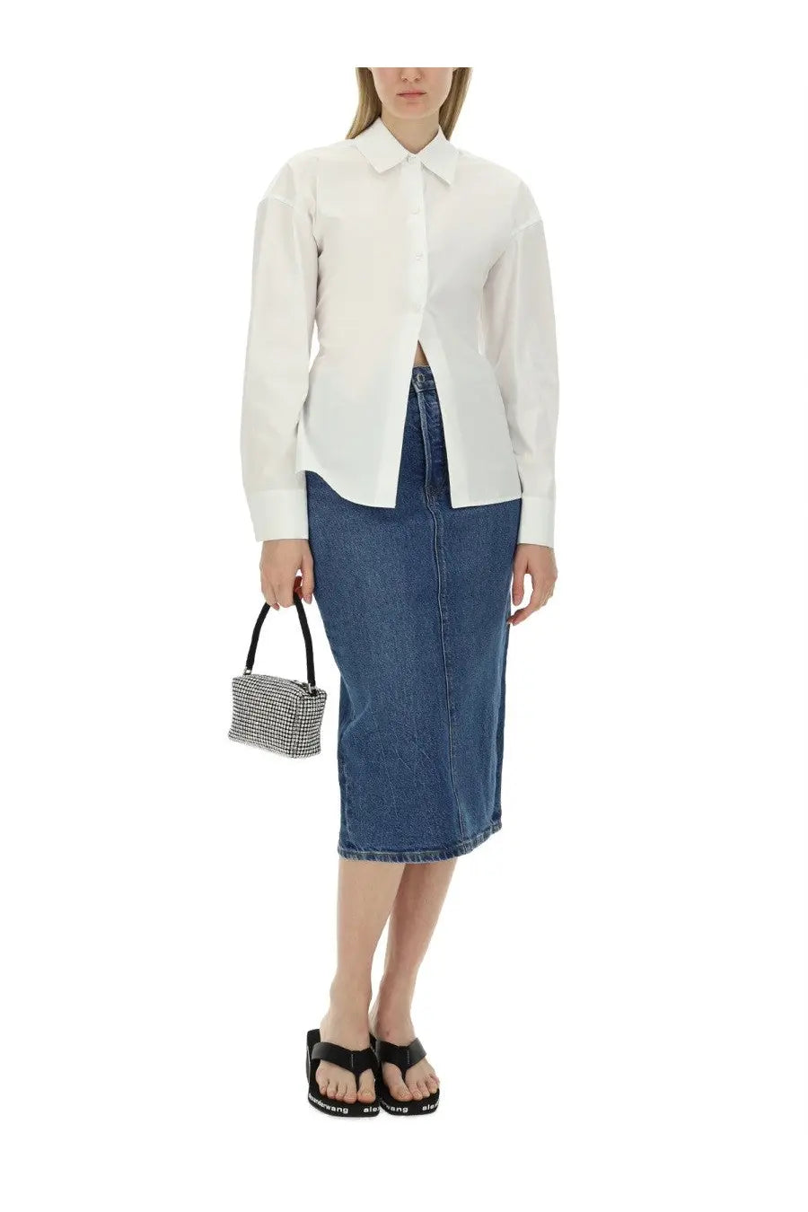 A small structured handbag with a black houndstooth pattern and black handles paired with alexanderwang blue midi skirt