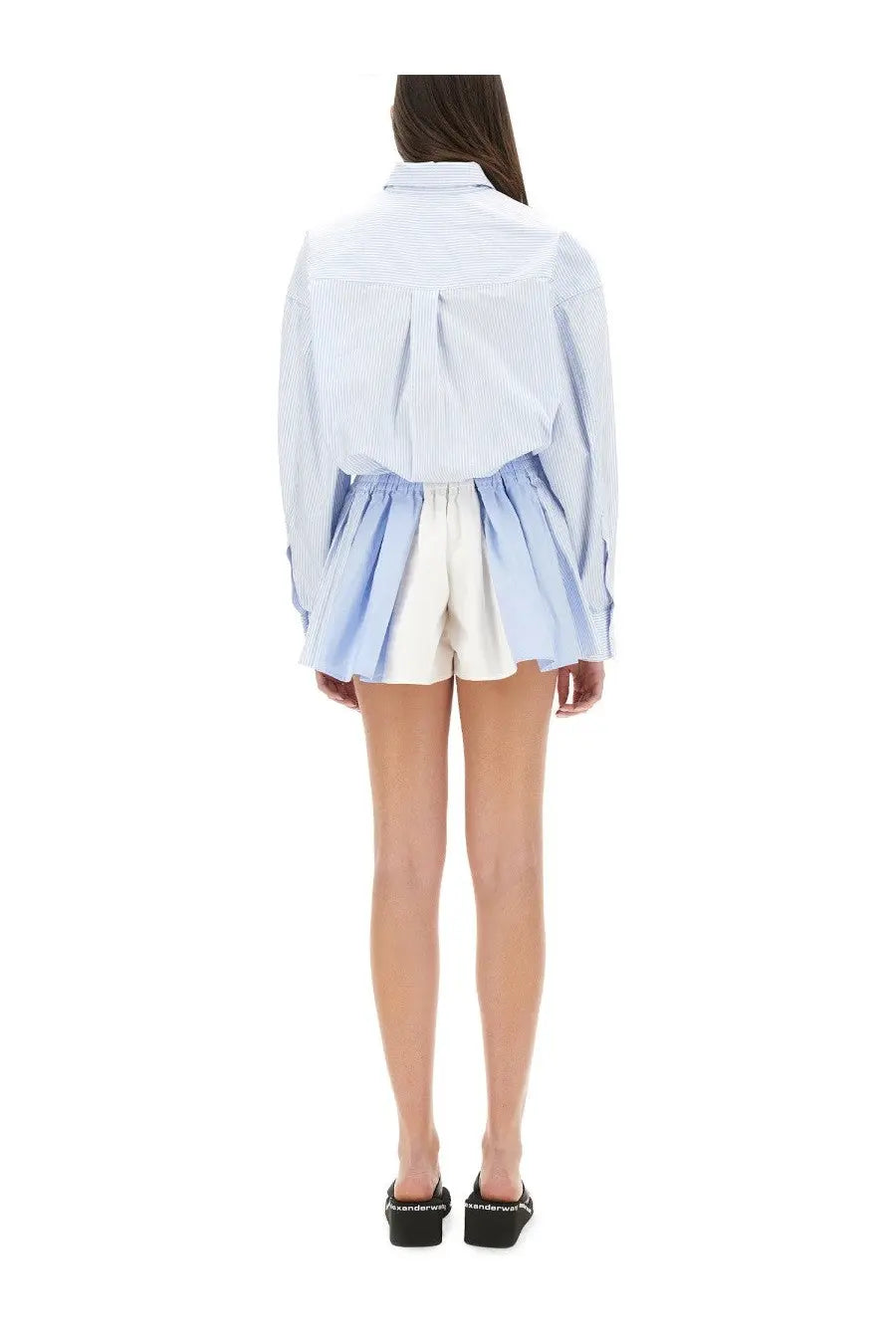 Alexanderwang women’s short blue striped overalls paired with a light blue and white striped long-sleeved shirt with relaxed fit
