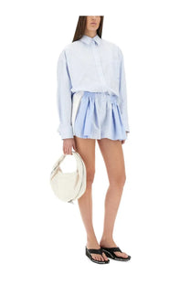Off-white circular handbag with single handle and visible stitching paired with alexanderwang blue short striped overalls