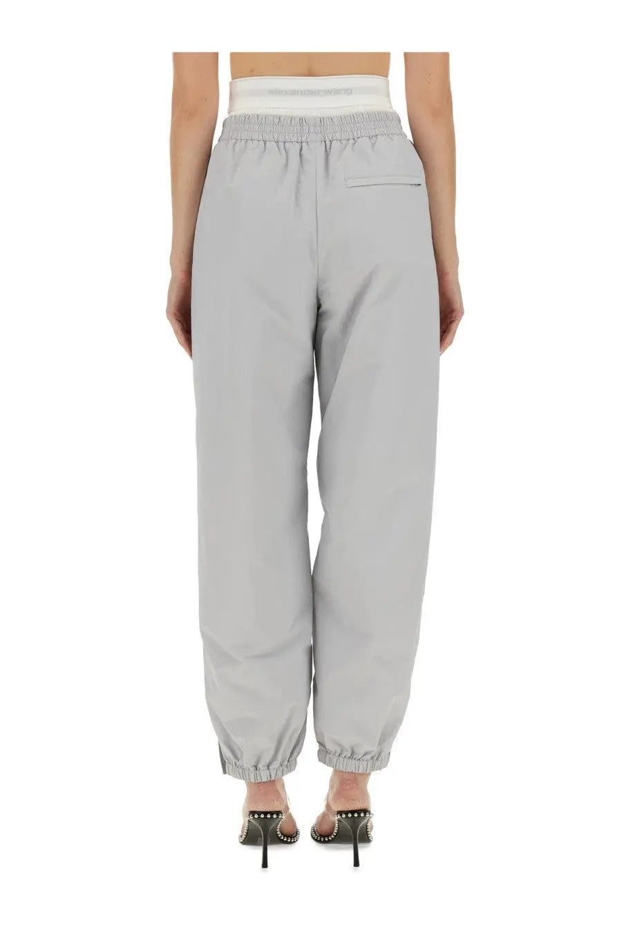 Light gray alexanderwang women’s sports pants with high waist elastic cuffs and subtle brand logo on waistband