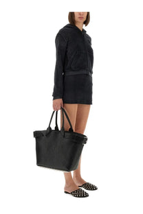 Black textured tote bag with studded trim paired with alexander wang women’s terry skirt pants black
