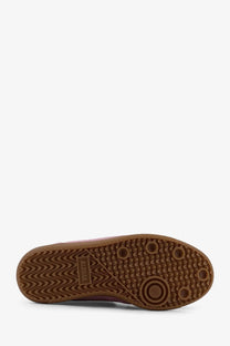 The back side of Alohas women’s TB suede sneakers blue showing a brown rubber sole with wavy tread and adidas label