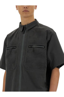 Alpha Industries men’s grey short sleeve shirt with textured mesh pattern and zippered pockets made of lightweight fabric
