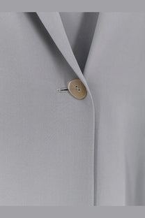 Alysi women’s loose silk blazer grey with a minimalist gold-toned button on the light gray suit lapel