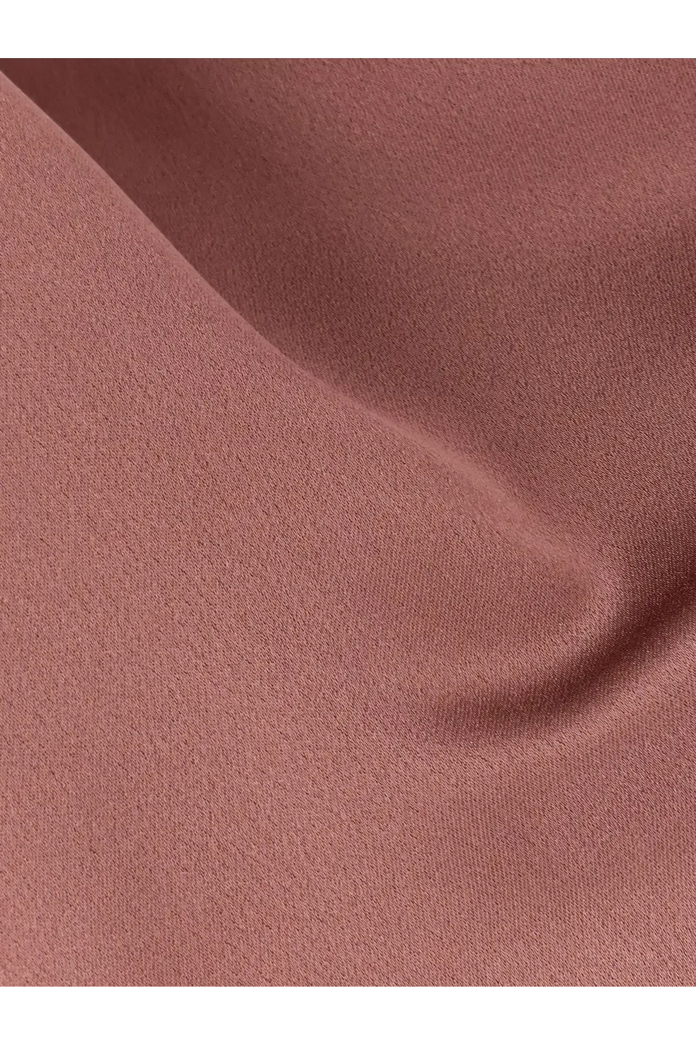 Alysi women’s satin top in blue shown with a soft dusty rose-colored fabric and smooth textured weave