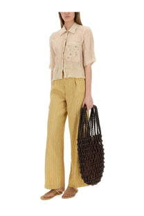 Brown woven tote bag with textured braided design paired with alysis beige striped satin tailored pants